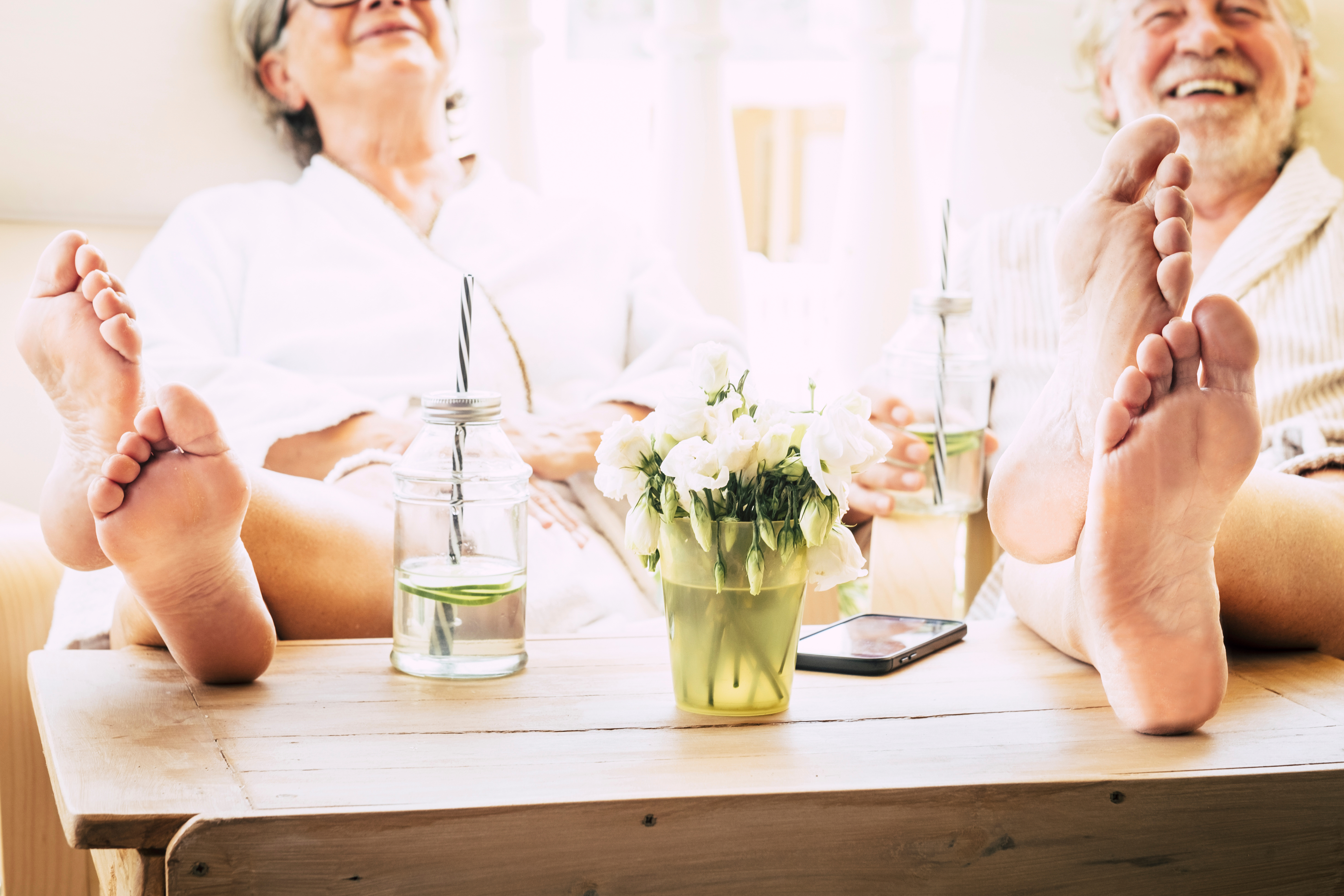 Two seniors smiling with bare feet